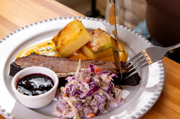 A fork and knife are used to cut a brisket.