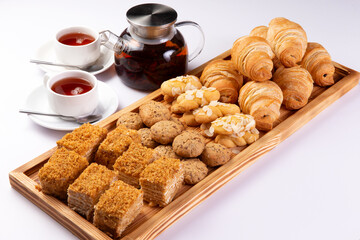 Various pastries and tea on a white background.