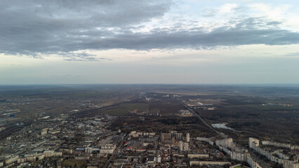 Aerial cityscape with high-rise buildings, green areas, and cloudy sky