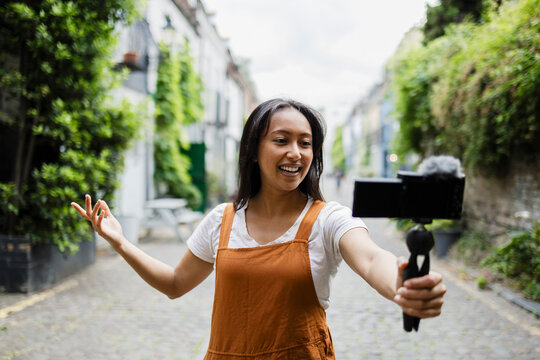 Vlogger recording content outdoors with smartphone and microphone