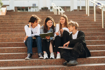 Fototapeta premium Under sunlight, sitting. Group of students are near university together