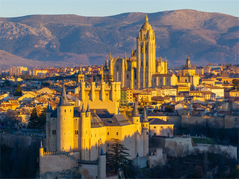 Aerial view of the Alc&Atilde;&iexcl;zar of Segovia and Segovia Cathedral stand majestically amidst the city's rooftops, bathed in the warm glow of a setting sun, Segovia, Castilla y Le&Atilde;&sup3;n, Spain.