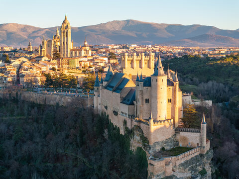 Aerial view of the Alc&Atilde;&iexcl;zar of Segovia's formidable stone silhouette against the soft glow of the rising sun, juxtaposed with the distant cathedral, Segovia, Castilla y Le&Atilde;&sup3;n, Spain.