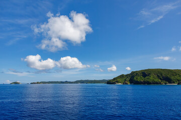 Fototapeta premium 慶良間諸島の座間味島等へゆく高速ジェットフェリー。 クイーンざまみ3号。 慶良間諸島に到着した。座間味島や阿嘉島、無人島の安室島、嘉比島、安慶名敷島などが見える。 ヨットやクルーズ船とすれ違う。 島には白砂のビーチや緑の森、灯台もある。 沖縄県島尻郡慶良間諸島-2025/6/27 