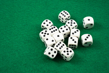 Several white dice with black dots are casually scattered on a green felt surface, creating a vibrant and playful atmosphere. The setting indicates a relaxed game night scene.