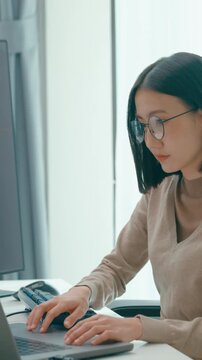 Vertical Screen : Young adult Asia female freelance eyeglasses typing write prompt AI bot app smart program nomad, video game, terminal coding, user interface, designer, big data center on computer.