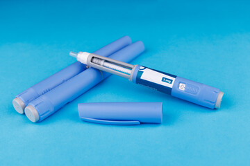 Semaglutide pens arranged neatly on blue table, emphasizing telehealth, wellness and healthcare support.
