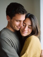 Obraz premium A young couple sharing a warm embrace indoors, showcasing love and affection. The soft lighting enhances the intimate mood of the moment.