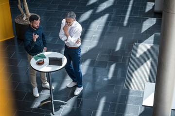 Manager and team member discussing business strategy in modern office