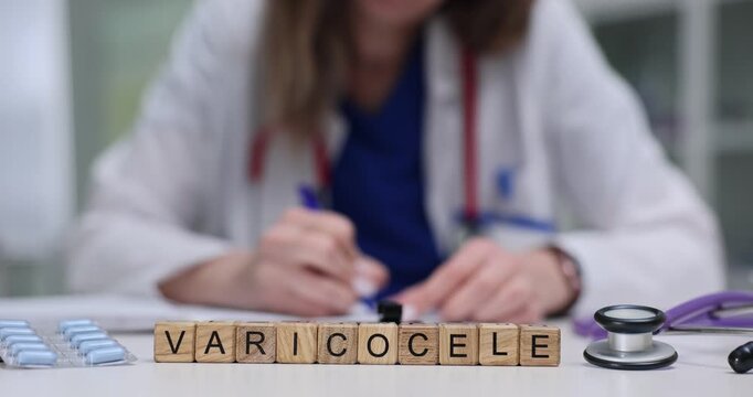 Female doctor writes prescription near Varicocele on wooden blocks on desk. Discussion diagnosis and explanation of varicocele in medical setting