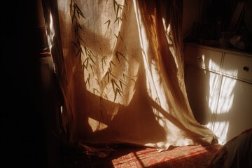 Sunlight streams through a tan curtain with bamboo print, casting shadows on a room