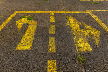 Navigating choices on an abandoned parking lot with faded directional lines in the warm light of...