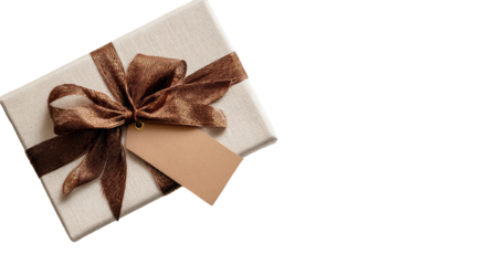 Gift box with brown ribbon and tag.  Cream-colored box, tied with a rich brown satin ribbon, creating a bow.  A blank tan tag hangs from the ribbon.  Isolated on black