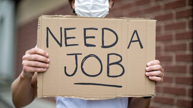 Unemployment and stagflation cause stress as person in mask holds cardboard sign reading need job outdoors, economic uncertainty
