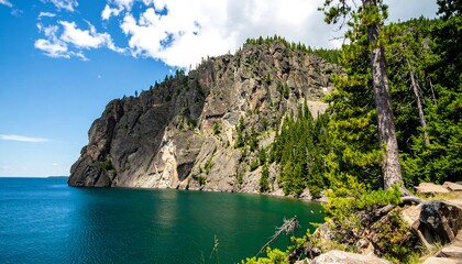 Obraz premium Rocky shoreline meets turquoise lake