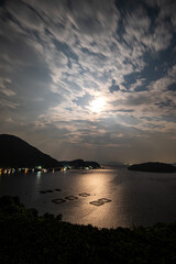 京都府伊根の若狭湾にのぼる満月と舟屋集落