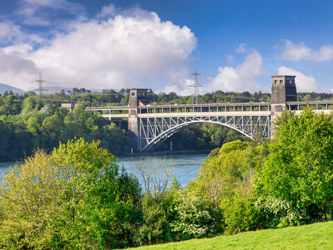 Britannia Bridge, Anglesey, was originally built across the Menai Strait between Anglesey and Bangor in 1850 by Robert Stephenson as a tubular bridge of wrought iron rectangular box-section spans.