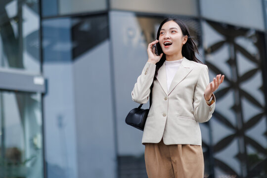 Businesswoman talking on phone outside office building