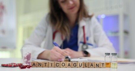 Wooden cubes spell Anticoagulant focusing on blood thinning medicine concept. Lab desk shows medical vials and paperwork creating research mood - Powered by Adobe