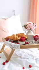 Romantic breakfast in bed with croissants and berries