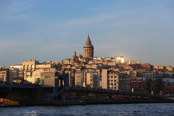 Galata Tower and Bridge in Istanbul at sunset, cityscape with golden light and waterfront view.