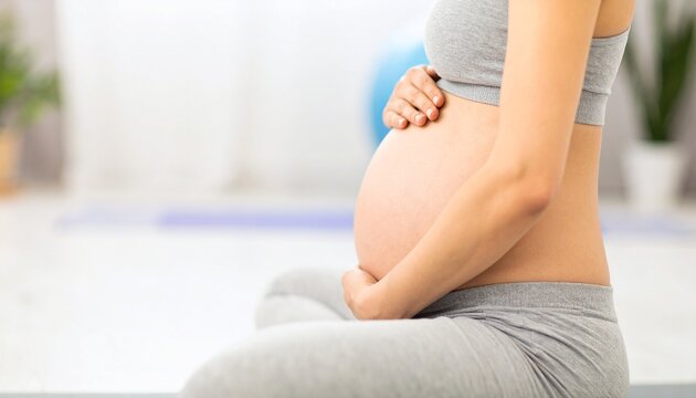 Pregnant woman meditating cross-legged at home - Powered by Adobe
