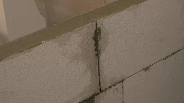 Watering joints in a construction scene, showcasing the gradual moisture absorption in masonry, highlighting the process of joint treatment. watering joints 