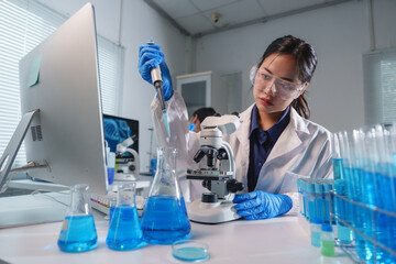 Fototapeta premium Scientist using micropipette and analyzing samples in laboratory
