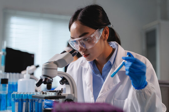 Scientist analyzing sample with microscope in laboratory research