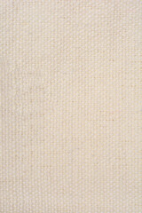 Fototapeta premium A full-frame, macro shot of a light beige, woven fabric with a visible texture