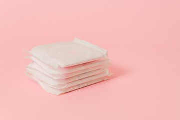 Sanitary pads packed on pink background. Concept of menstruation, ovulation, reproduction, pain and personal hygiene. Flat layout