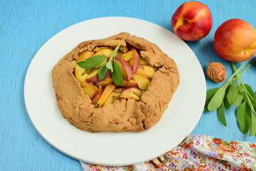 Nectarine galette with sage and honey on blue background
