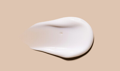 texture of creamy white moisturizer on beige background, skin care product