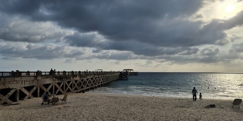 Sunset stroll at the beach pier cancun scenic landscape photography serene ocean vibe distant perspective family memories