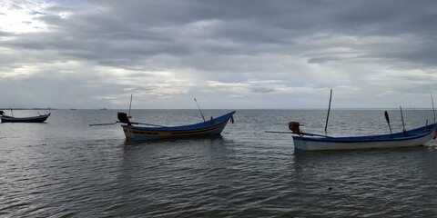 Fishing boats docked in calm waters coastal landscape photography overcast sky serene seascape nature's beauty