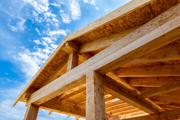 Obraz premium Wooden construction framework under a bright blue sky