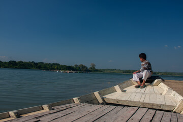 young man sitting on a pier