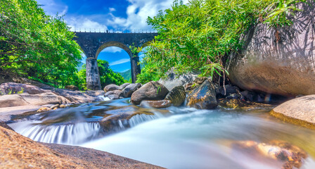 Scenery on Hai Van Pass passing through the most beautiful railway bridge in Vietnam, peaceful landscape, stream flowing under the bridge © huythoai