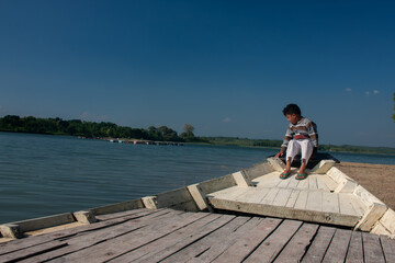 young man sitting on pier