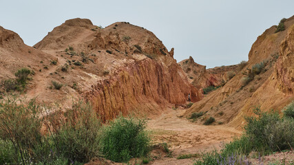 Path in Fairytale Canyon, among orange and yellow rocks, Kyrgyzstan.