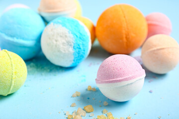 Different bath bombs and sea salt on color background, closeup