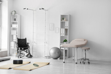 Interior of physiotherapist's office with sports equipment, couch and wheelchair