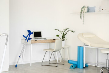 Interior of physiotherapist's office with workplace, couch and sports equipment