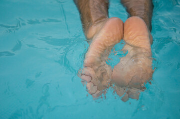 Feet of a person swimming in the pool