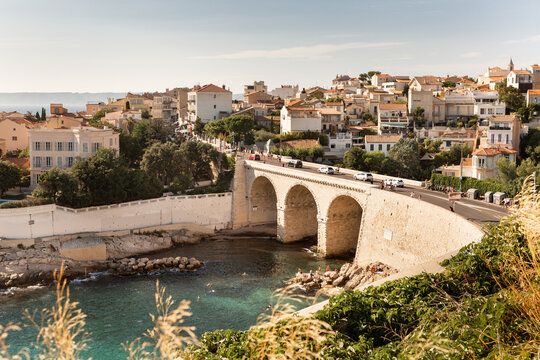 Ville de Marseille, vue sur le pont de la Anse de la Fausse Monnaie et de la Corniche Kennedy, baigneurs dans la mer et sur les rochers, ville en arri&egrave;re plan, sud de la France, M&eacute;diterran&eacute;e