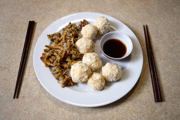 Bowl of dumplings with soy sauce and brown sugar for serving