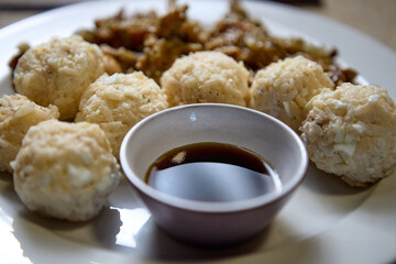 Traditional steamed dumplings with soy sauce in ceramic bowls