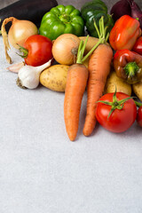 Assortment of fresh bright vegetables on a gray background for cooking. The concept of naturalness, healthy eating.