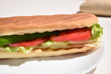 close up sandwich with slices of tomato, cucumber, lettuce leaf and cheese