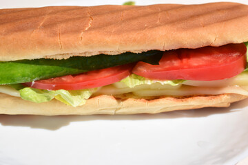 close up sandwich with slices of tomato, cucumber, lettuce leaf and cheese